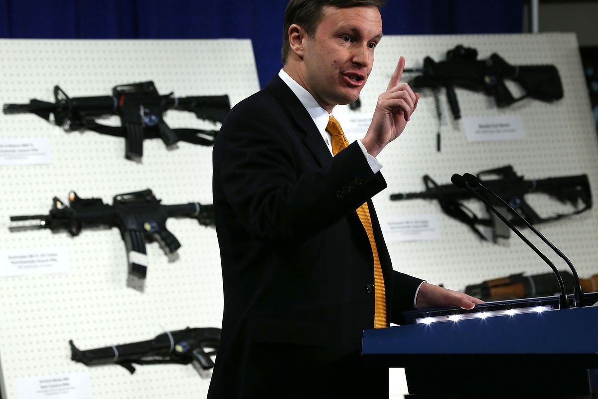 Sen. Chris Murphy speaks about gun violence in front of a display of assault rifles in 2013.