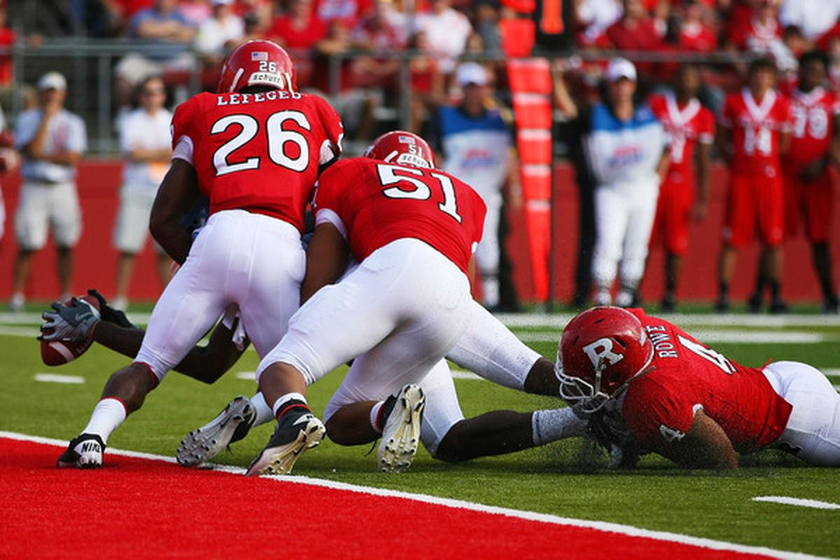 Dwight Jones #83 of the North Carolina Tar Heels is held short of the goal line by Joe Lefeged #26 Manny Abreu #51 and David Rowe #4 of the Rutgers Scarlet Knights during the second quarter at Rutgers Stadium.