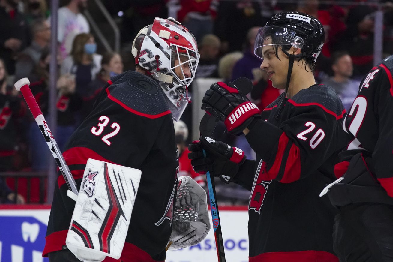 Oct 29, 2021; Raleigh, North Carolina, USA; Carolina Hurricanes goaltender Antti Raanta (32) and right wing Sebastian Aho (20) celebrate their victory against the Chicago Blackhawks at PNC Arena.