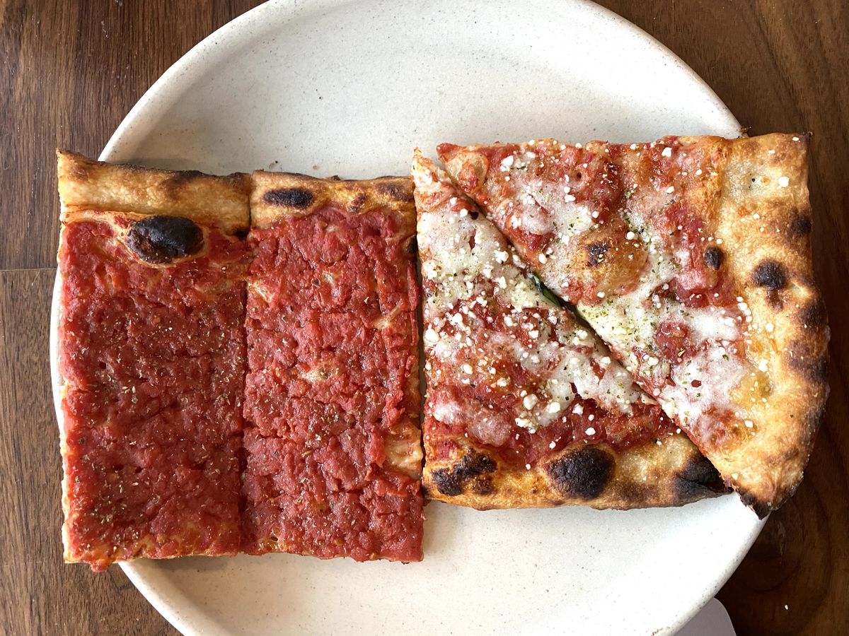 A crimson marinara slice (left), and cheese slice (right), sit on a plate at Leo