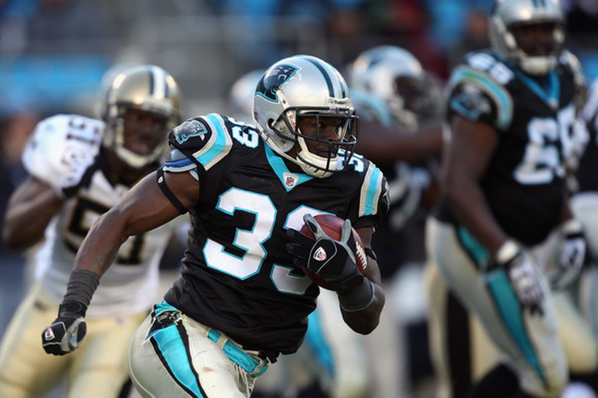 Mike Goodson #33 of the Carolina Panthers runs with the ball against the New Orleans Saints with Jonathan Vilma trailing wishing he had placed a bounty on him.