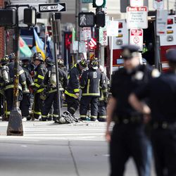 Firefighters gather one block from Boylston Street following an explosion at the finish line of the Boston Marathon in Boston, Monday, April 15, 2013.  Two bombs exploded at the Boston Marathon finish line Monday killing at least two people injuring dozens. 