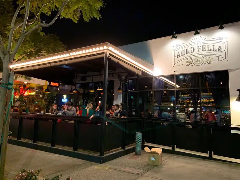 An Irish restaurant with a full patio shown at night.