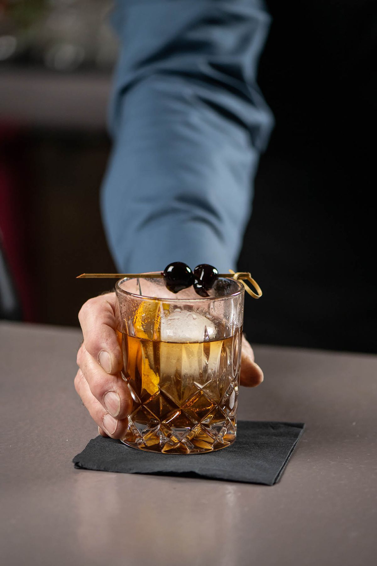 A barkeep presents his version of an Old Fashioned at the Rendition Room.