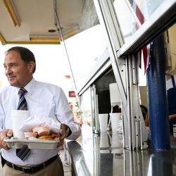Gov. Gary Herbert picks up an order consisting of a burger, fries, onion rings and a soda during an event at Burger Bar in Roy on Tuesday, June 7, 2016. Herbert visited the restaurant to read a proclamation honoring its founder, Ben Fowler, who recently died at 96, and to campaign for re-election.