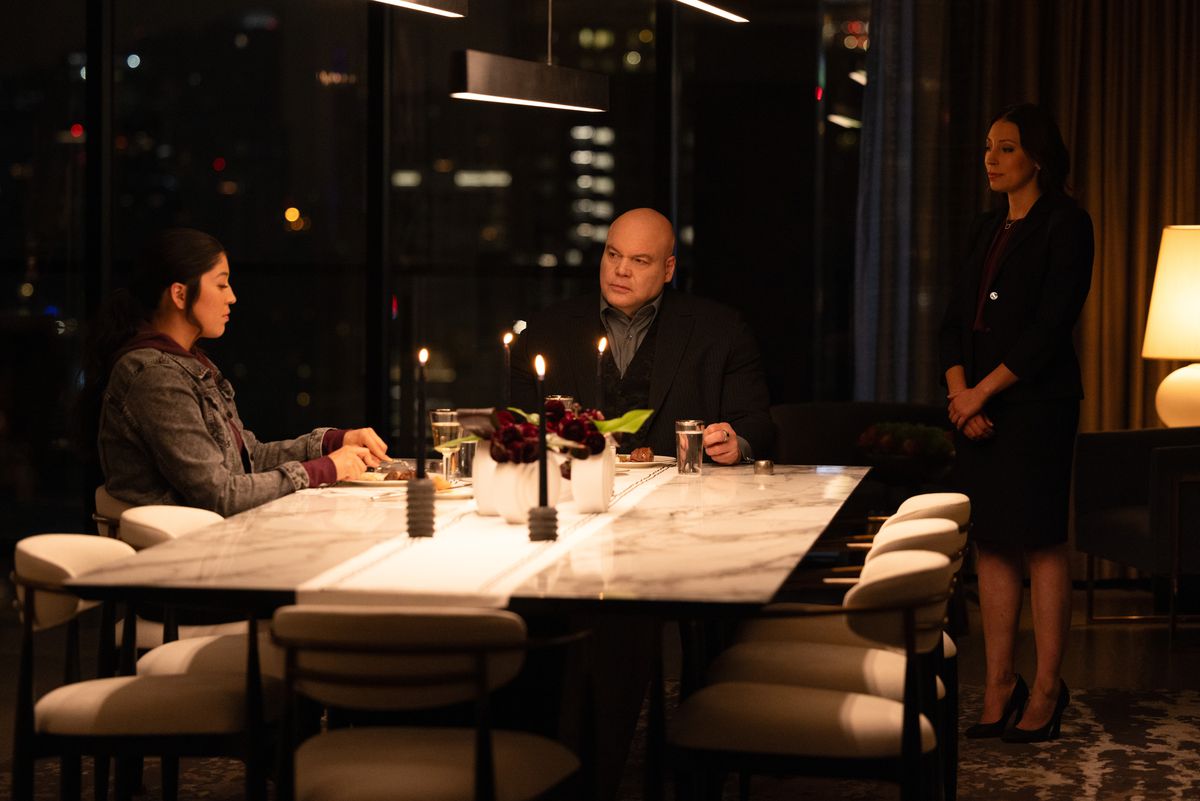Echo (Alaqua Cox) and Kingpin (Vincent D’Onofrio) sit at a table with an ASL translator standing over his shoulder