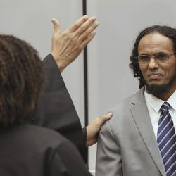 Ahmad Al Faqi Al Mahdi, right, a Malian Islamic extremist who pleaded guilty to destruction of historic mausoleums in Timbuktu, Mali, listens to his defense team as he enters the courtroom to hear the verdict of the International Criminal Court in The Hague, Netherlands, Tuesday, Sept. 27, 2016.