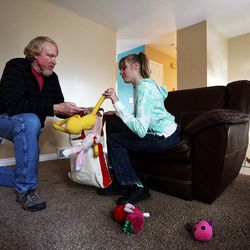 Doug Rice picks up toys with his daughter, Ashley, at their home in West Jordan on Wednesday, Nov. 16, 2016.