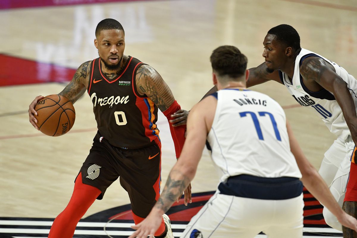PORTLAND, OREGON - MARCH 21: Damian Lillard #0 of the Portland Trail Blazers handles the ball against Luka Doncic #77 and Dorian Finney-Smith #10 of the Dallas Mavericks during an NBA game at Moda Center on March 21, 2021 in Portland, Oregon. The Dallas Mavericks beat the Portland Trail Blazers 132-92. NOTE TO USER: User expressly acknowledges and agrees that, by downloading and or using this photograph, User is consenting to the terms and conditions of the Getty Images License Agreement.