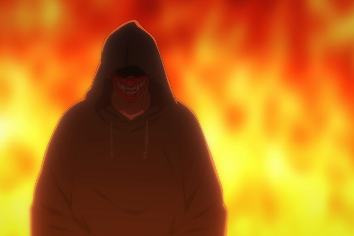 A man wearing a black hoodie and a red mask covering the lower half of his face walking away from a roaring fire.