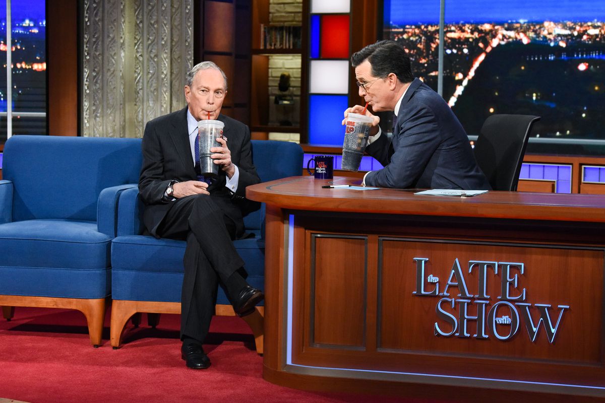 Michael Bloomberg and Stephen Colbert sip on giant sodas.