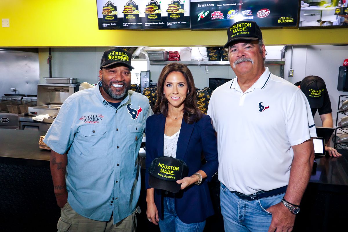 Houston rapper Bun B stands next to Houston Texans Foundation vice president Hannah McNair and Texans chair and CEO Cal McNair in front of Trill Burgers’s NRG concession stand.