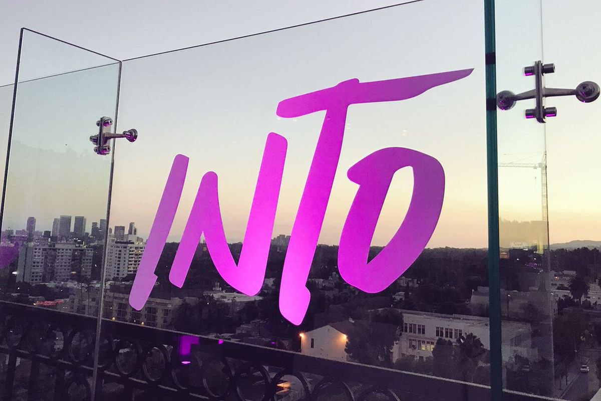 The Into logo written on a pane of glass, through which is a cityscape