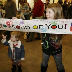 Gabrielle and Camille Preston, Orem, hold a sign for their mother as the Utah Hospital Task Force members return.