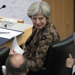 British Prime Minister Theresa May speaks to an aid during a high level meeting on the situation in Libya, Wednesday, Sept. 20, 2017 at United Nations headquarters.
