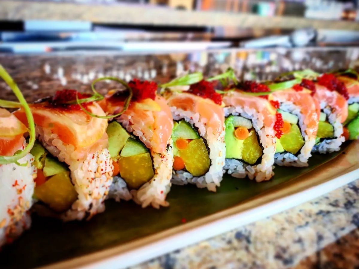 sushi roll topped with raw salmon