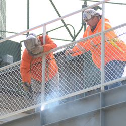 11:19 a.m. Welding into place the fence at the back of the left-field bleachers - 