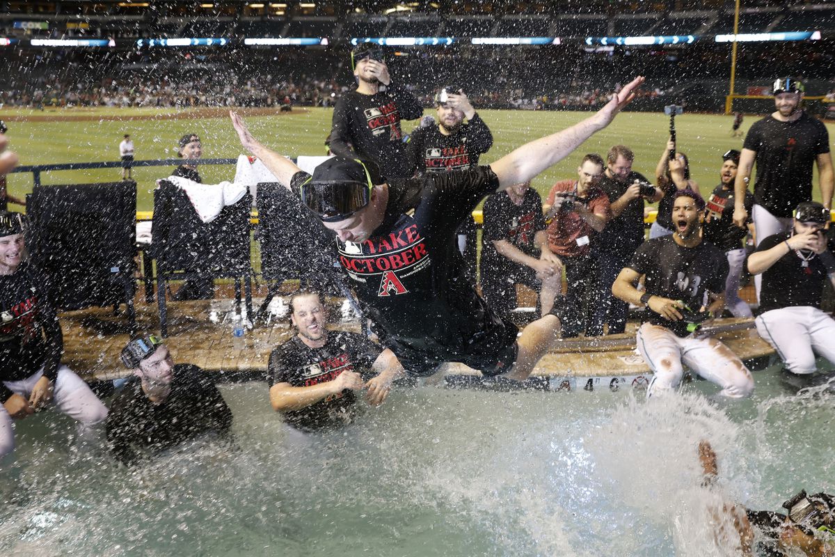 Arizona Diamondbacks players celebrate in the Chase Field pool after clinching a National League Wild Card playoff spot after the game against the Houston Astros on September 30, 2023 in Phoenix, Arizona.  