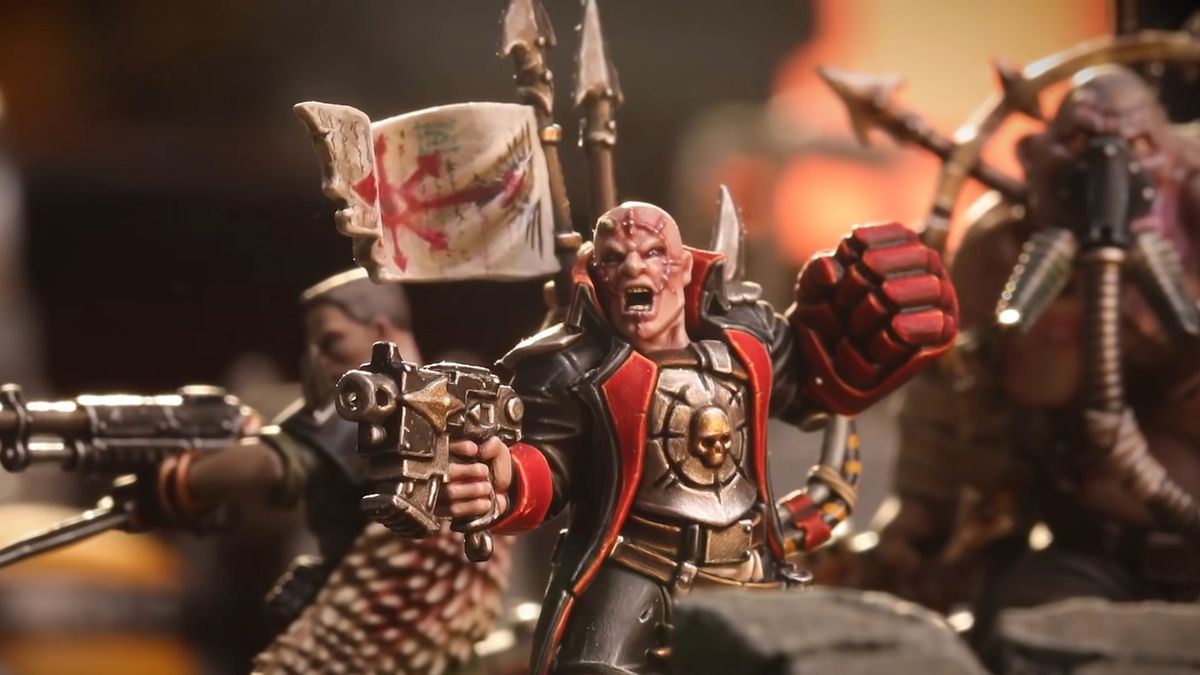 A traitor Imperial Guard Commissar, a political officer, yells. He has a massive left arm.