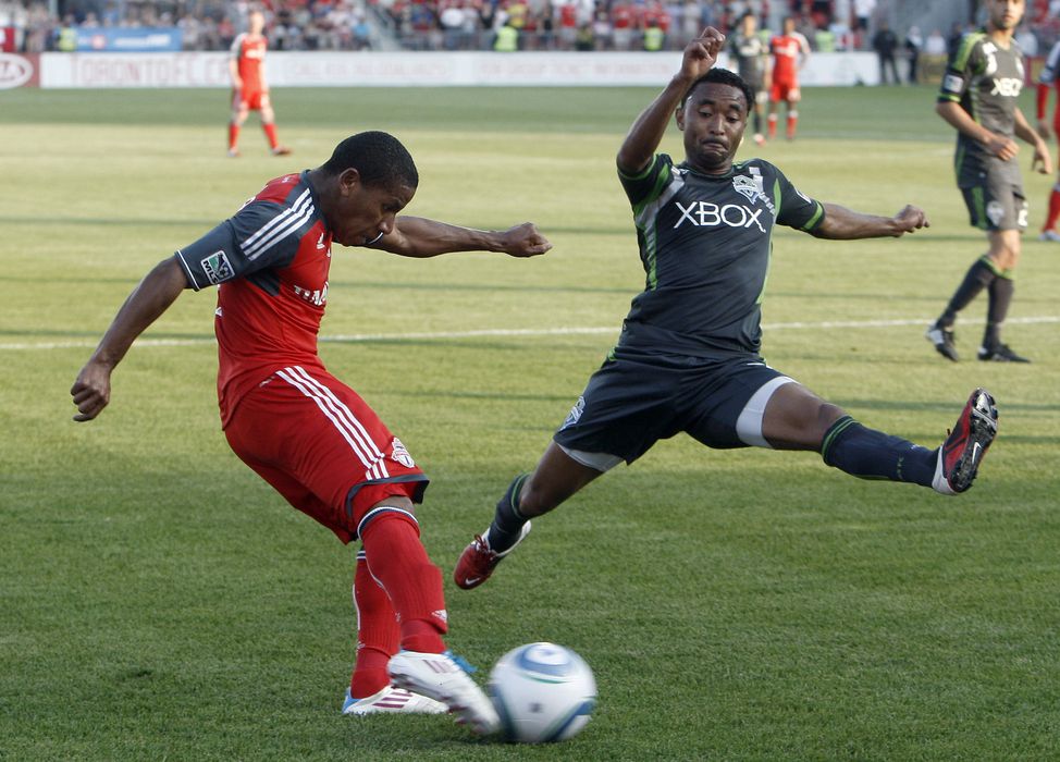TORONTO, CANADA - JUNE 18:  Joao Plata #7 of Toronto FC shoots past James Riley #7 of Seattle Sounders FC during MLS action at BMO Field June 18, 2011 in Toronto, Ontario, Canada. (Photo by Abelimages/Getty Images)