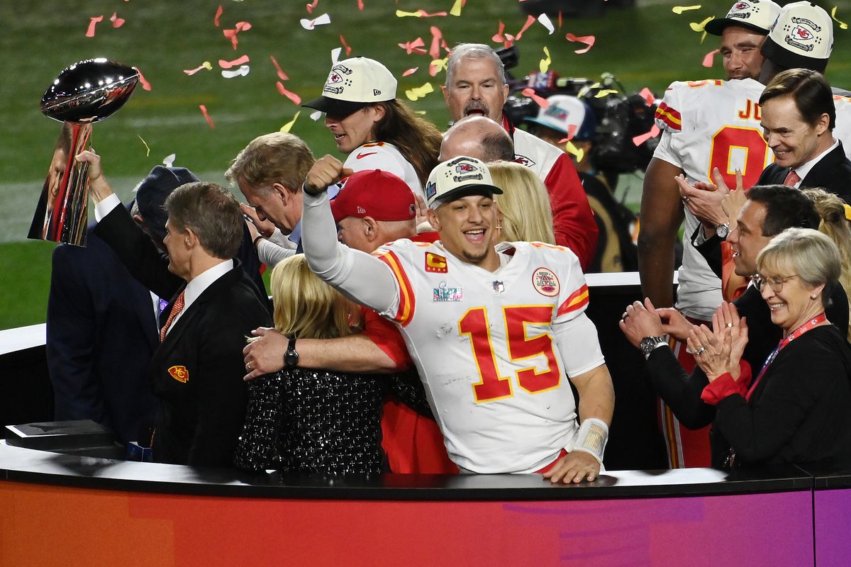 Head coach Andy Reid and quarter back Patrick Mahomes #15 of the Kansas City Chiefs stands on the podium with owner Clark Hunt celebrating with the Lombardi Trophy after they defeated the Philadelphia Eagles 38-35 in Super Bowl LVII at State Farm Stadium on February 12, 2023 in Glendale, Arizona.