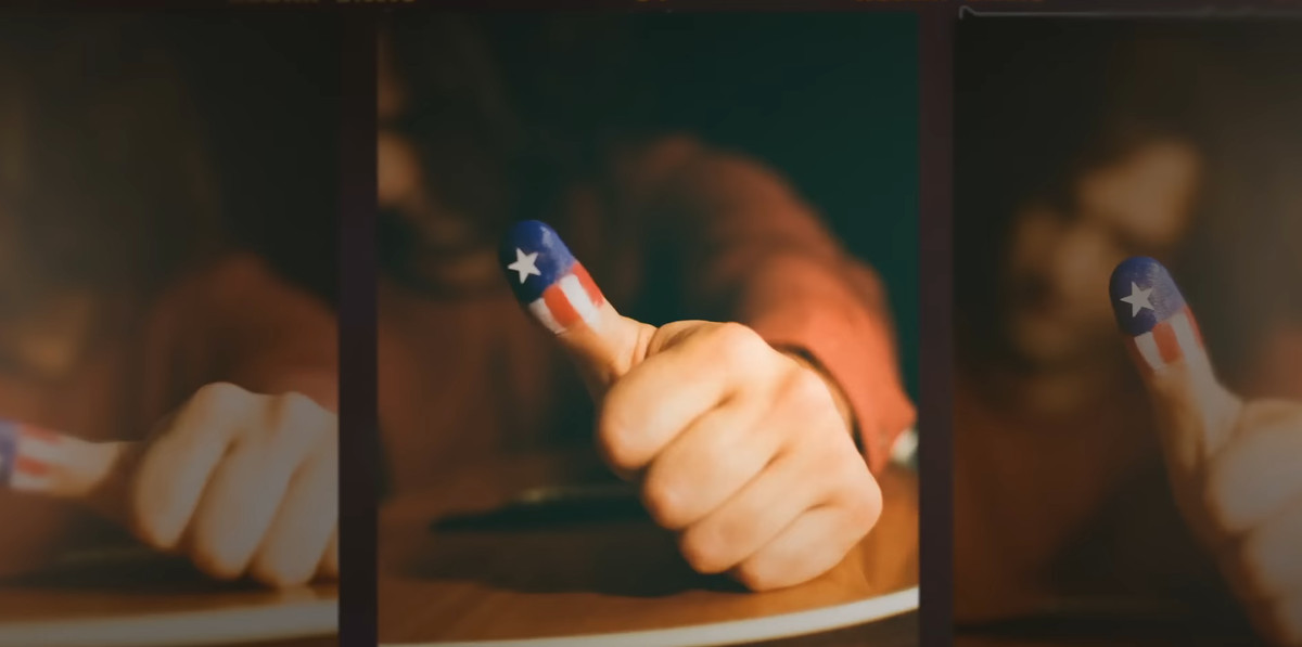 A photo of a thumb painted with the stars and stripes of the American flag.