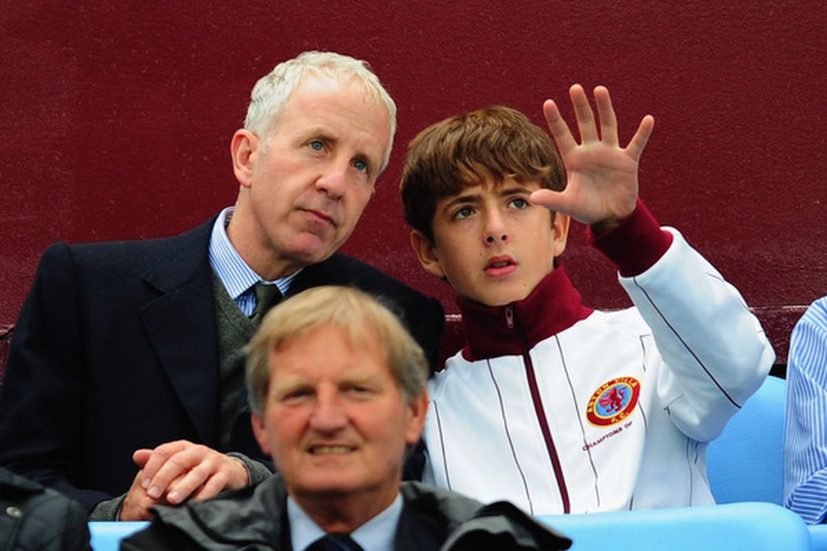 Randy Lerner listens patiently as a child explains his vision of Aston Villa in the Europa League. (Photo by Jamie McDonald/Getty Images)