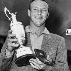 File-This July 15, 1961, file photo shows Arnold Palmer smiling with his trophy and medal after winning the British Open Golf Championship by a single stroke at Royal Birkdale course in Birkdale, Lancashire, England. Palmer, who made golf popular for the masses with his hard-charging style, incomparable charisma and a personal touch that made him known throughout the golf world as "The King," died Sunday, Sept. 25, 2016, in Pittsburgh. He was 87.