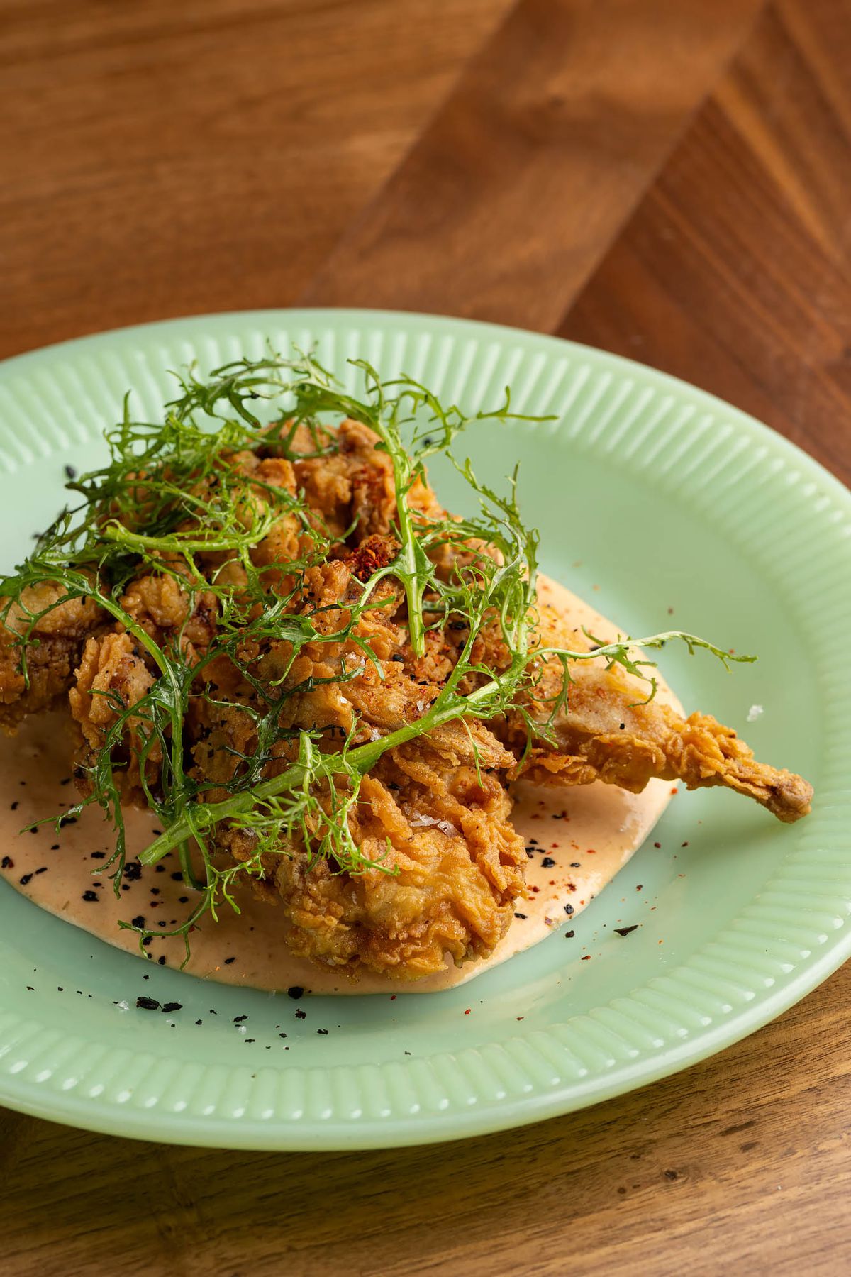 Jerk fried quail, tomato aioli, mustard frill, and aleppo at PleasureMed’s restaurants in West Hollywood.