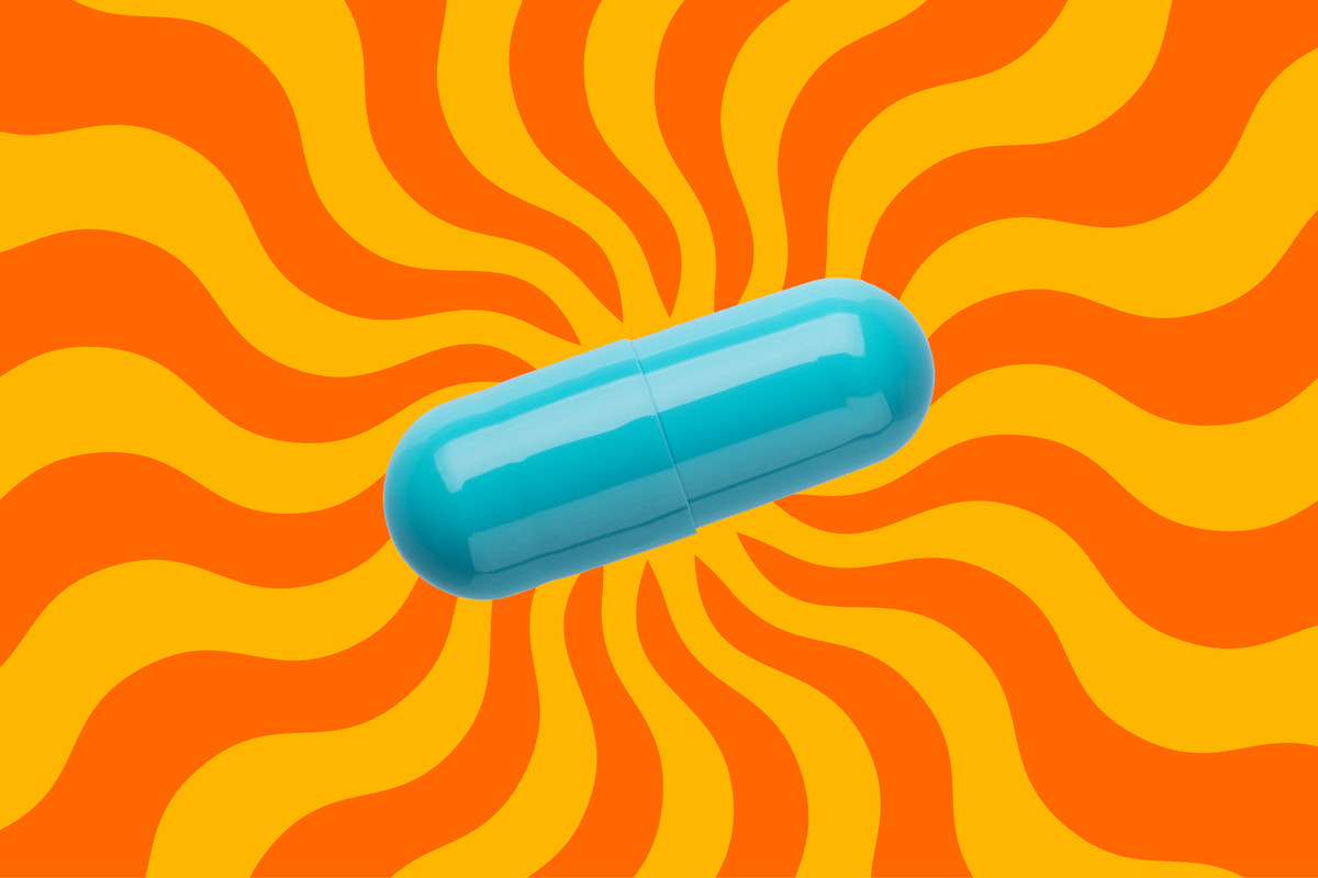 A turquoise capsule on a background of orange and yellow wavy rays of sun.