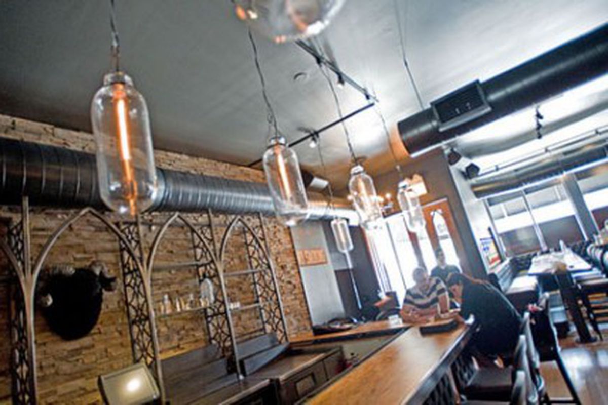 The main bar with gothic shelves and Edison bulbs