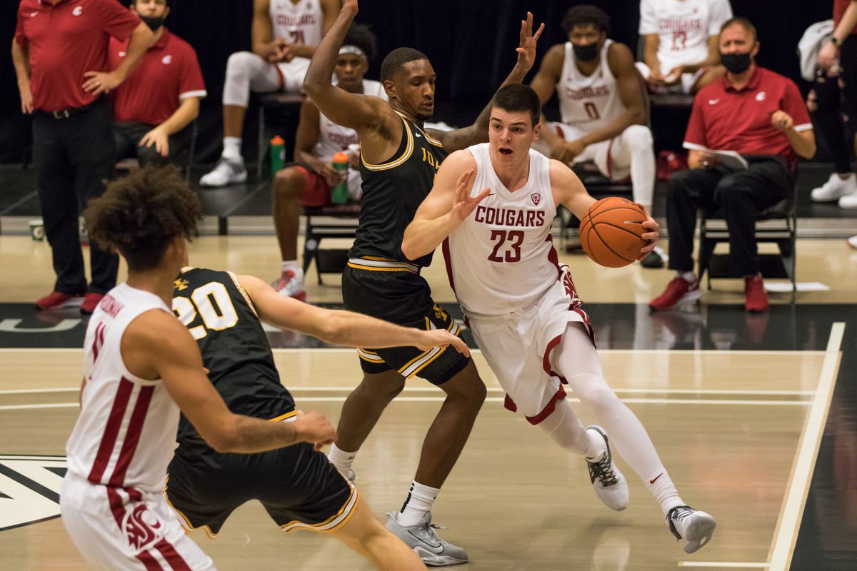 PULLMAN, WA - DECEMBER 9: Washington State forward Andrej Jakimovski (23) pushes past an Idaho defender during the second half of the Battle of the Palouse rivalry between the Idaho Vandals and the Washington State Cougars on December 9, 2020, at Beasley Coliseum in Pullman, WA.