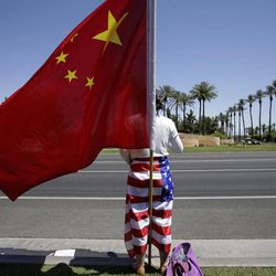 Rona Zhang, a supporter of Chinese President Xi Jinping, waits for the arrival of Xi Jinping in Indian Wells, Calif., Saturday, June 8, 2013, near where President Barack Obama and Xi were wrapping up a two-day summit at which they tackled the contentious issue of cybersecurity and tried to forge closer ties between the leaders of the world's largest economies. 