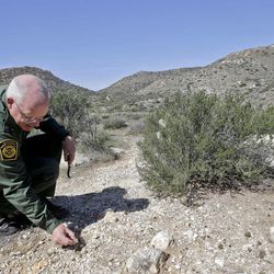 In this Monday, March 25, 2013 photo, Border Patrol agent Richard Gordon, a 23-year veteran of the agency, examines color changes in the soil which tell him volumes about human traffic where illegal immigrants enter the United States in the Boulevard area east of San Diego  in Boulevard, Calif. For the past 16 years, Gordon has been one of the top "sign-cutters" or trackers in the Border Patrol. 