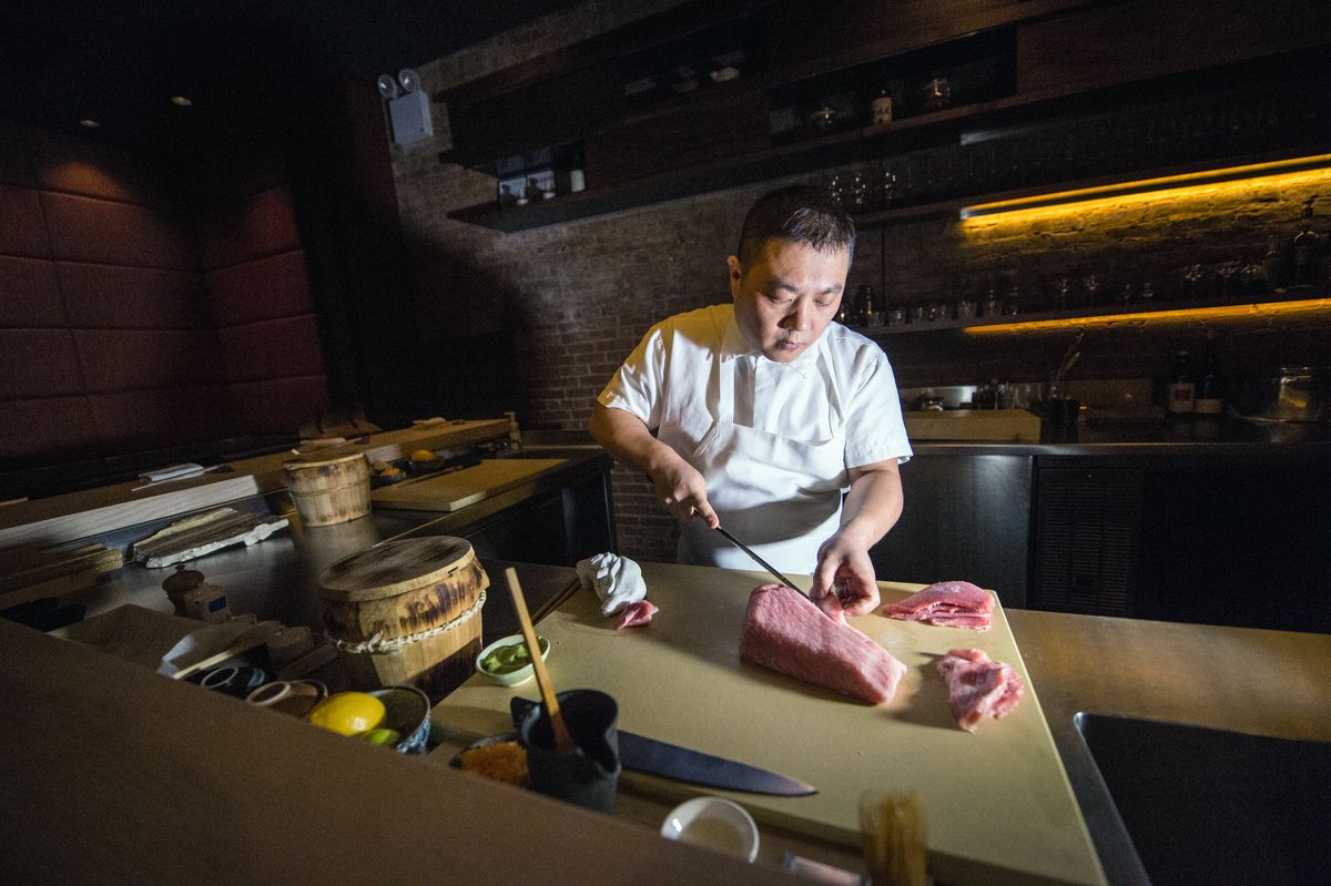 Shuko chef Jimmy Lau uses a long blade to slice pink fatty tuna before service