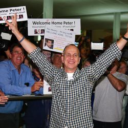 Australian journalist Peter Greste waves to supporters after he arrived in Brisbane, Australia, Thursday, Feb. 5, 2015. Greste, a reporter for Al-Jazeera English was released from an Egyptian prison and deported after more than a year behind bars. 