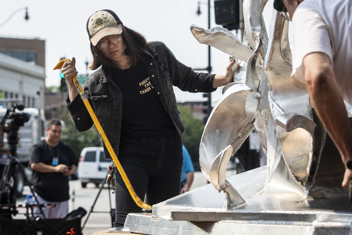 Artist Gwen Yen Chiu, the Chicago Sculpture Exhibit’s 2021 Richard Hunt Award winner, helps with the installation of her sculpture “Thought Vortex” at the intersection of Lincoln Avenue and Halsted Street on the North Side, Monday morning, July 19, 2021. The 12-foot-tall aluminum sculpture visually depicts a tornado in its center.