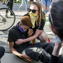 A woman comforts a boy who was pepper sprayed during a protest on May 29, 2020 in Denver, Colorado.