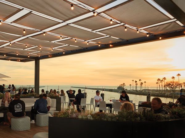 A brewery with outdoor seating overlooking the sunset in Long Beach, California.