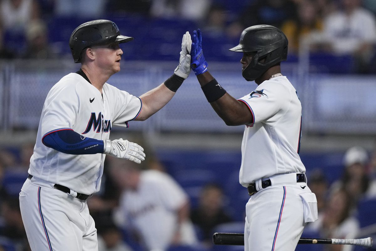 Garrett Cooper #26 of the Miami Marlins high fives Jorge Soler #12 after hitting a home run in the sixth inning against the San Francisco Giants at loanDepot park on June 05, 2022 in Miami, Florida.