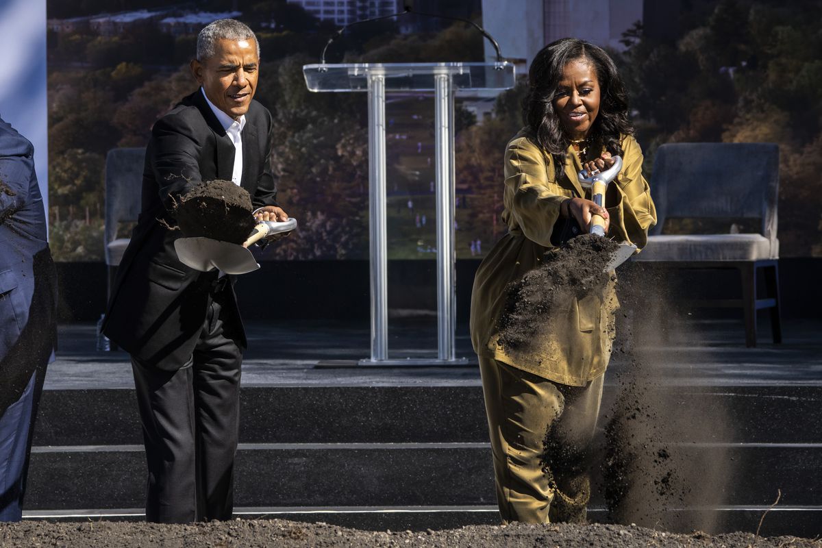 Former President Barack Obama, left, and former first lady Michelle Obama toss shovels of dirt during a groundbreaking ceremony for the Obama Presidential Center, Tuesday, Sept. 28, 2021.