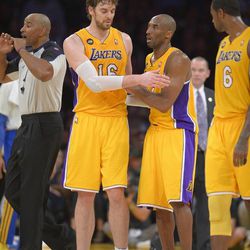 Los Angeles Lakers guard Kobe Bryant, center, is helped off the court by forward Pau Gasol, of Spain, as forward Earl Clark looks on after being injured during the second half of their NBA basketball game against the Golden State Warriors, Friday, April 12, 2013, in Los Angeles. The Lakers won 118-116. (AP Photo/Mark J. Terrill)