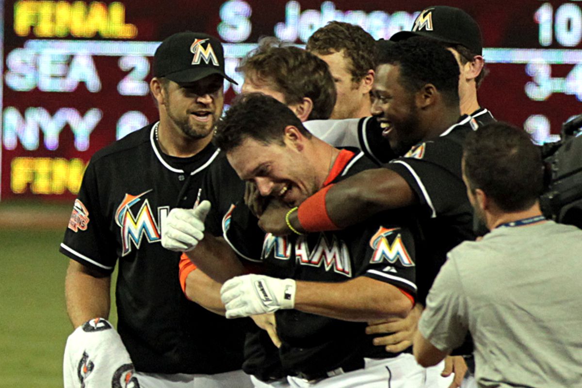 The Miami Marlins’ Hanley Ramirez, hugs teammate Greg Dobbs as they celebrate a 6-5 win against the New York Mets at Marlins Park in Miami, Florida