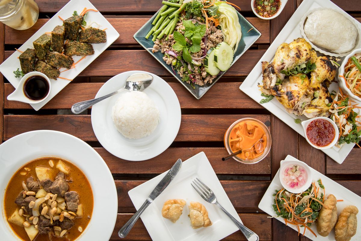 A spread of Thai food on a wooden table.
