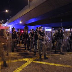 Riot police line up outside the Liaison Office in Hong Kong, Sunday, July 21, 2019. Protesters in Hong Kong pressed on Sunday past the designated end point for a march in which tens of thousands repeated demands for direct elections in the Chinese territory and an independent investigation into police tactics used in previous demonstrations. (AP Photo/Bobby Yip)