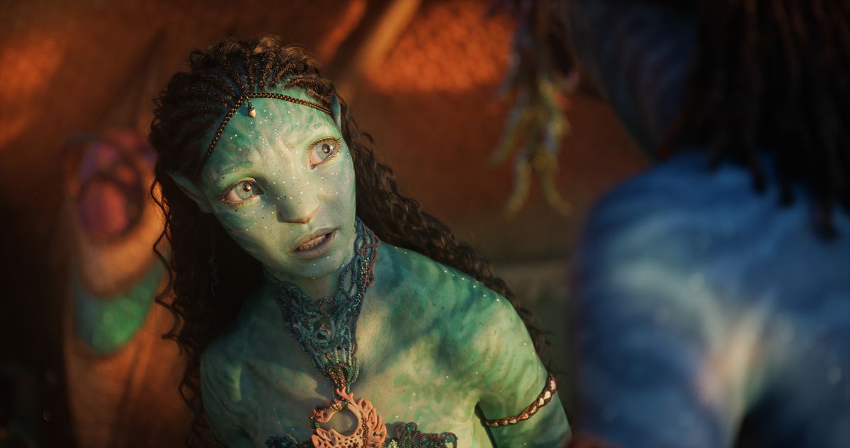 a pretty na’vi girl with turquoise skin, long curly black hair, and big blue eyes in avatar: the way of water