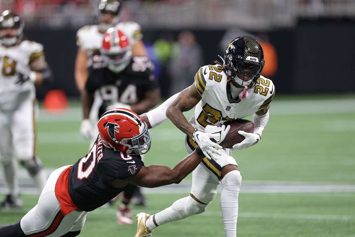 Rashid Shaheed of the New Orleans Saints is tackled with the ball by Lorenzo Carter #0 of the Atlanta Falcons in the second quarter of the game at Mercedes-Benz Stadium on November 26, 2023 in Atlanta, Georgia.