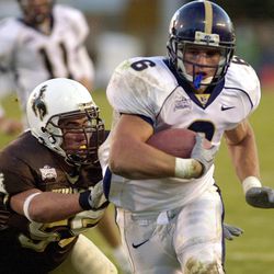 BYU running back Luke Stanley (6) slips by Wyoming defender Tam Pruitt on a 6-yard touchdown run in the fourth quarter of their Mountain West Conference football game in Laramie, Wyoming, Saturday, Nov. 10, 2001. It was Stanley's fourth touchdown of the game and gave BYU a 41-34 win over Wyoming.