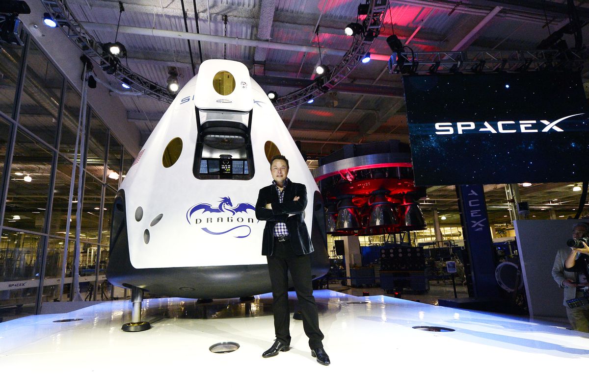 SpaceX CEO Elon Musk standing in front of the company’s manned spacecraft, The Dragon V2.