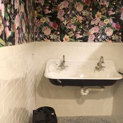 The wallpaper in the women's bathroom is an ode to LaCroix's floral works.